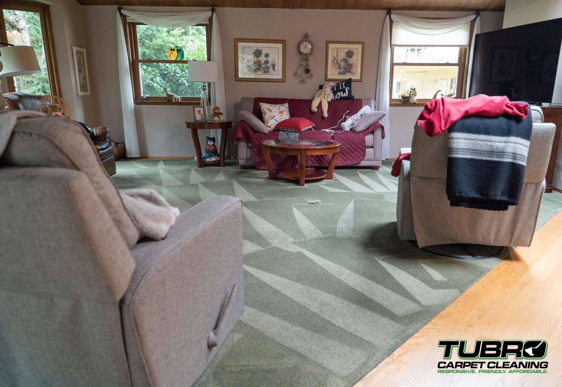 A living room with a couch , chairs , and a rug.