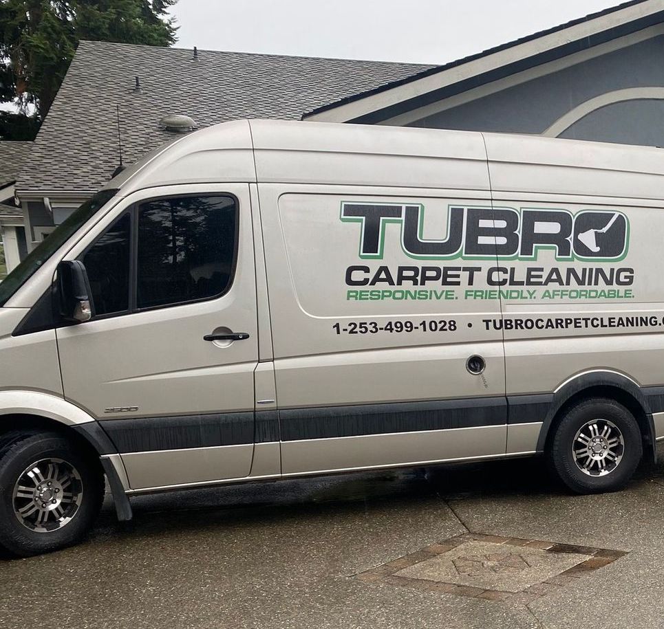 A tubro carpet cleaning van is parked in front of a house