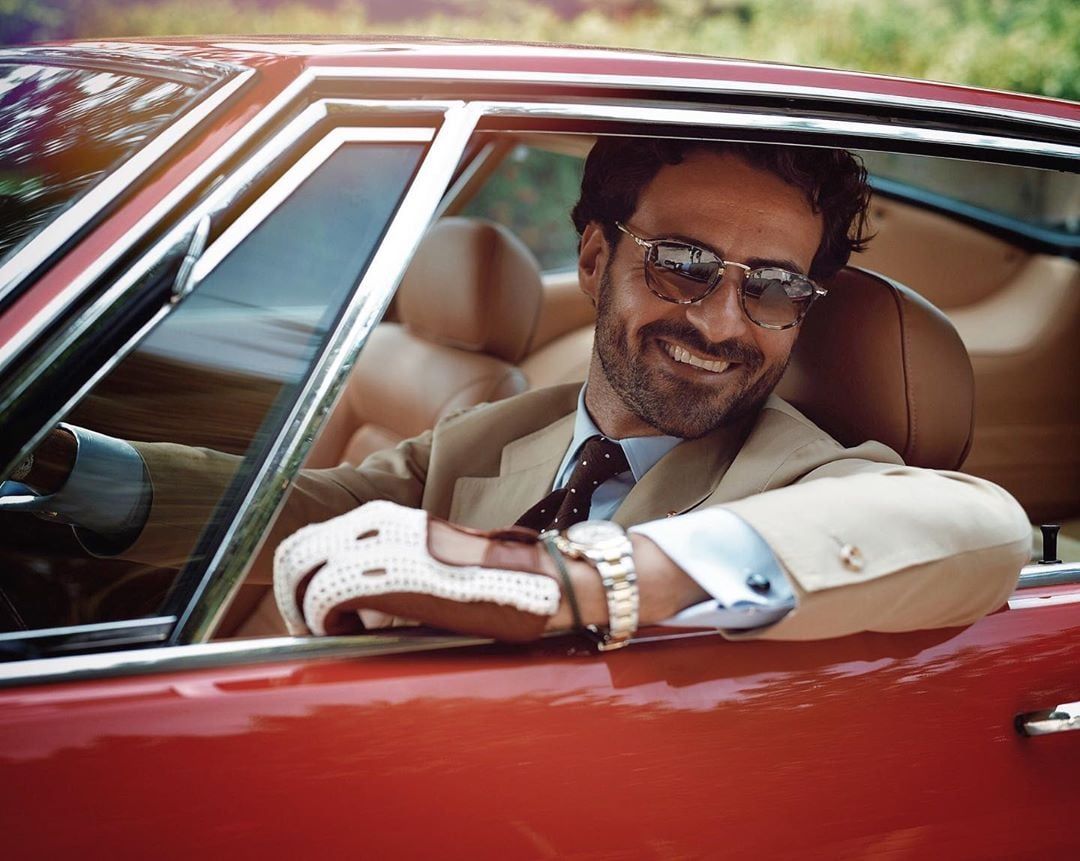 un uomo in macchina con gli occhiali da sole