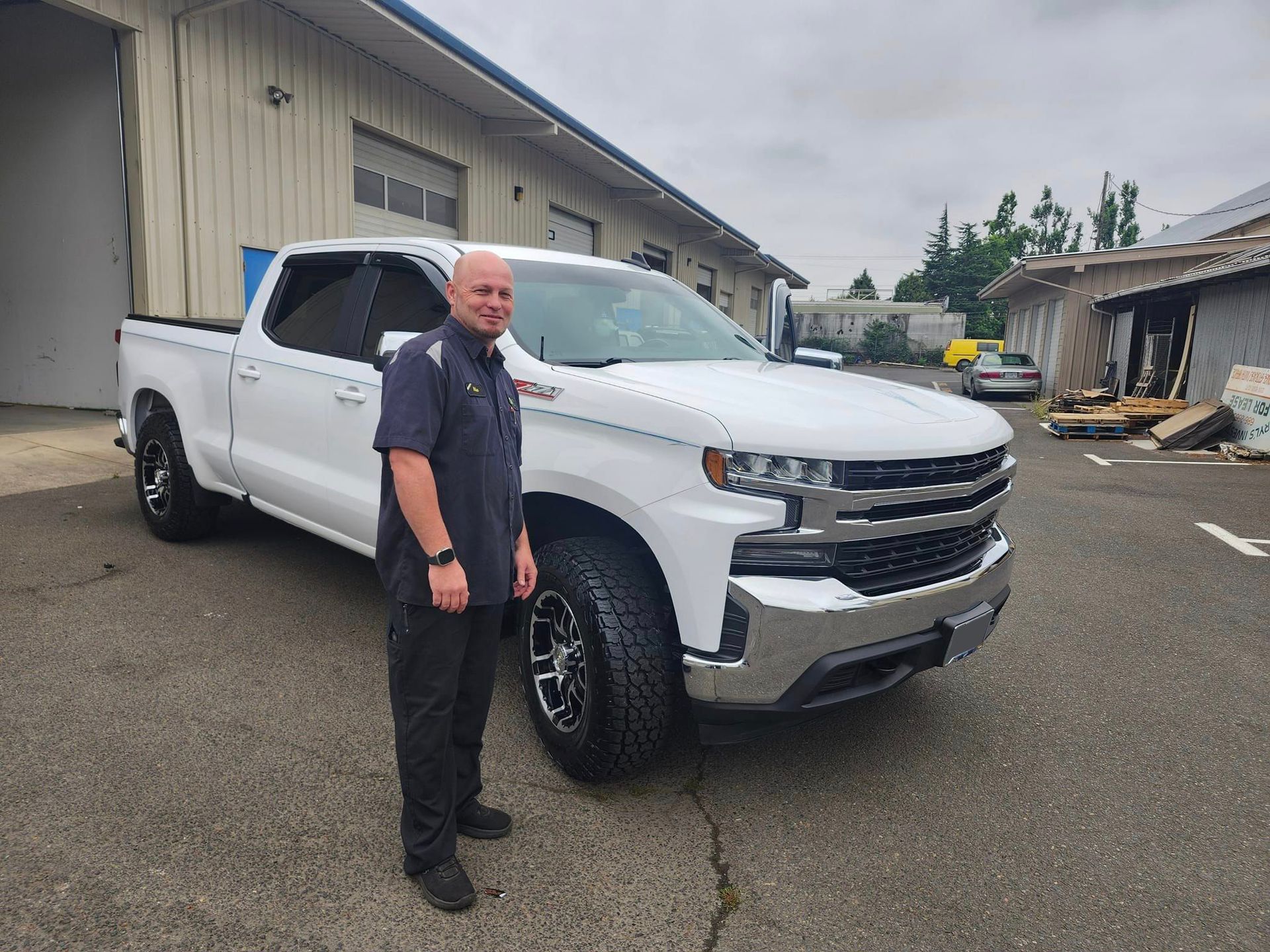 A man is standing in front of a white truck. | Oakmont Service Center