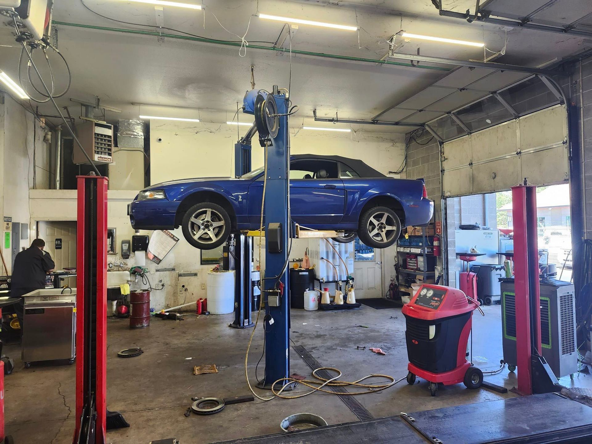 A blue car is on a lift in a garage. | Oakmont Service Center