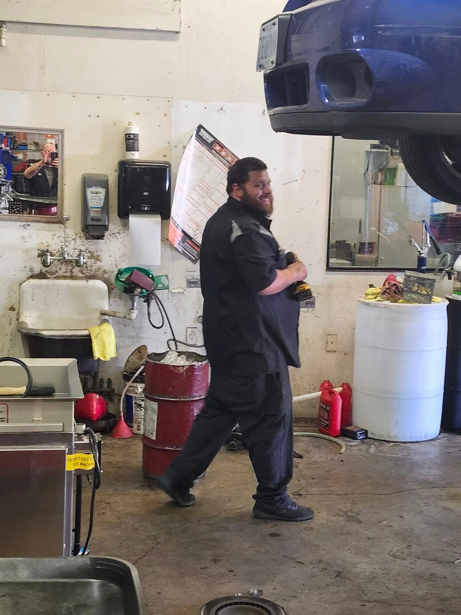 A man is working on a car in a garage | Oakmont Service Center