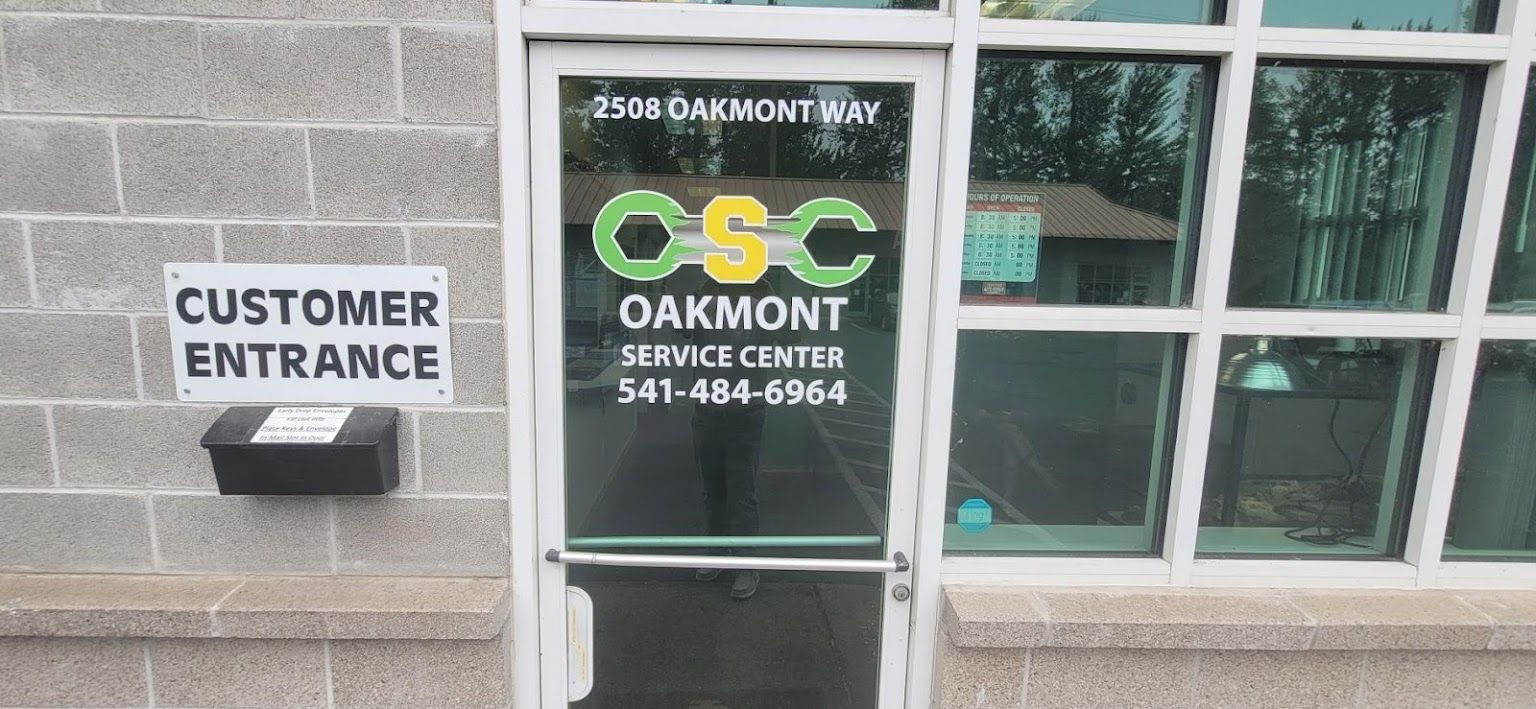 A customer entrance sign is on the side of a building. | Oakmont Service Center