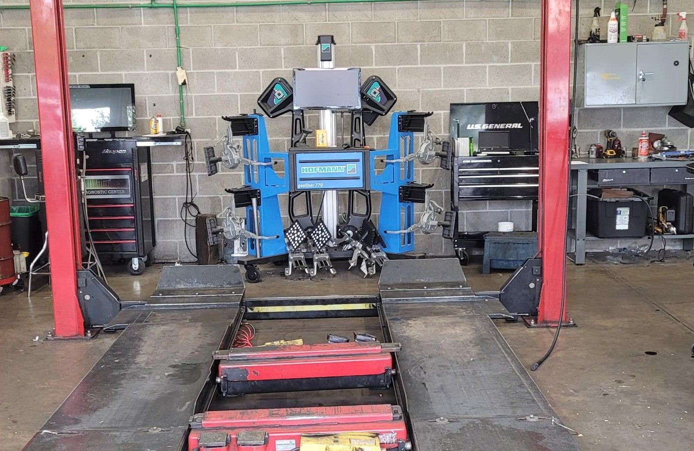 A machine is sitting on a lift in a garage. | Oakmont Service Center