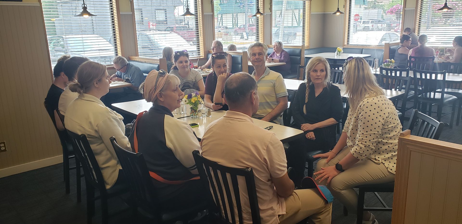 A group of people are sitting around a table in a restaurant.