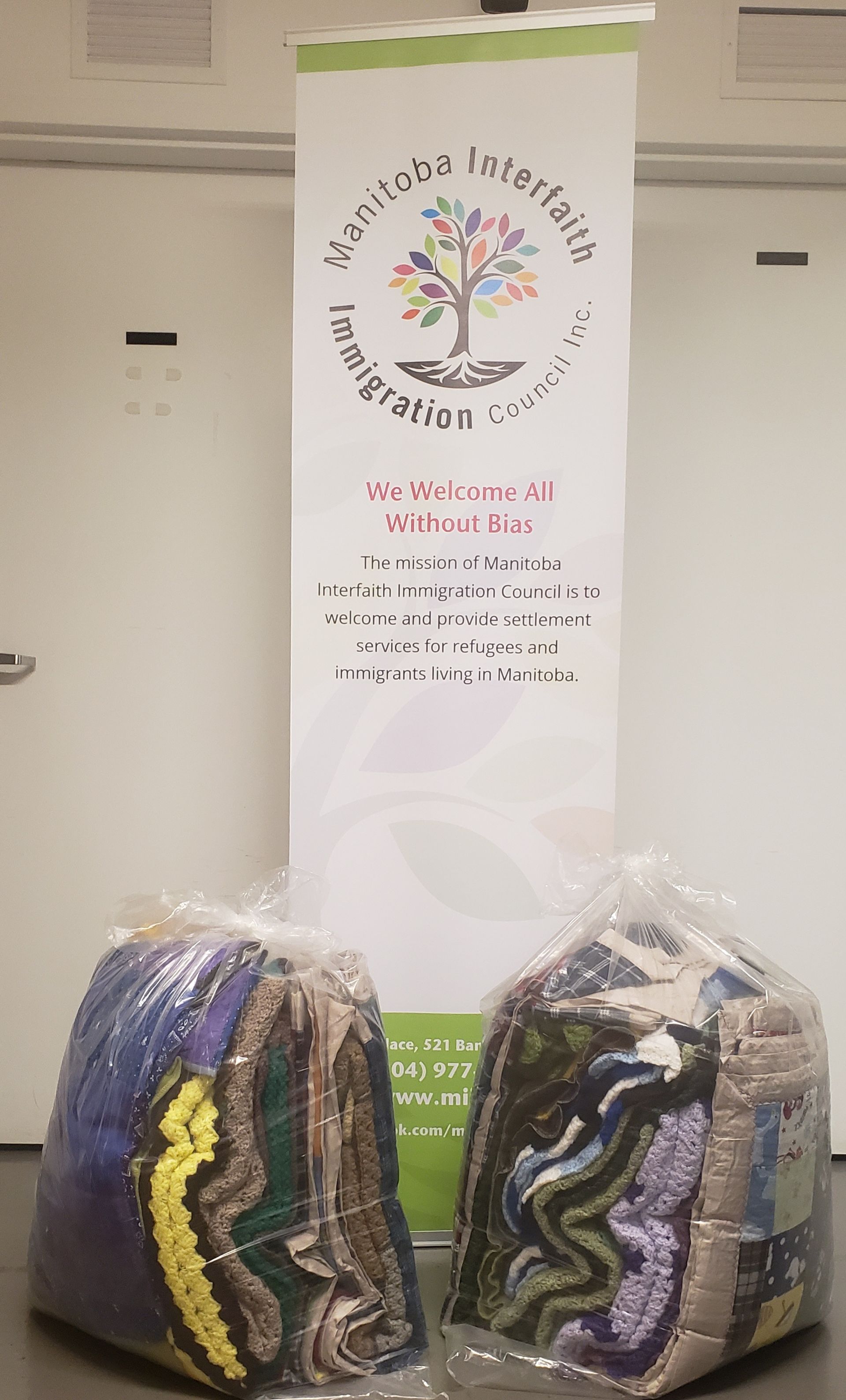 Two bags of yarn are sitting next to a sign.