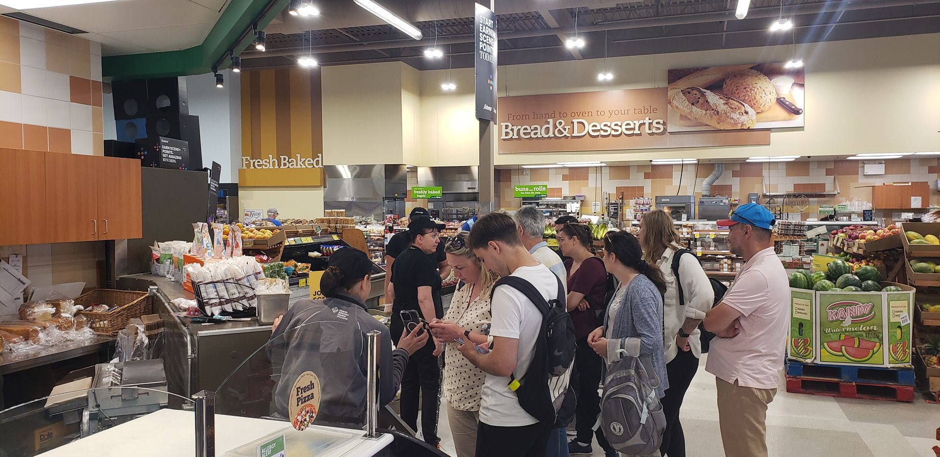 A group of people are standing in line at a grocery store.