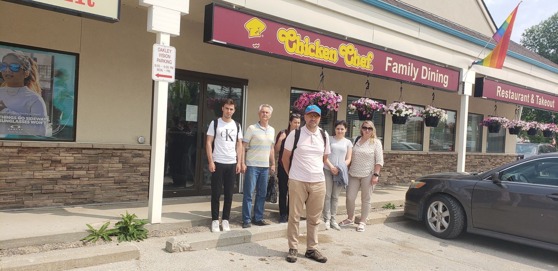 A group of people are standing in front of a restaurant.