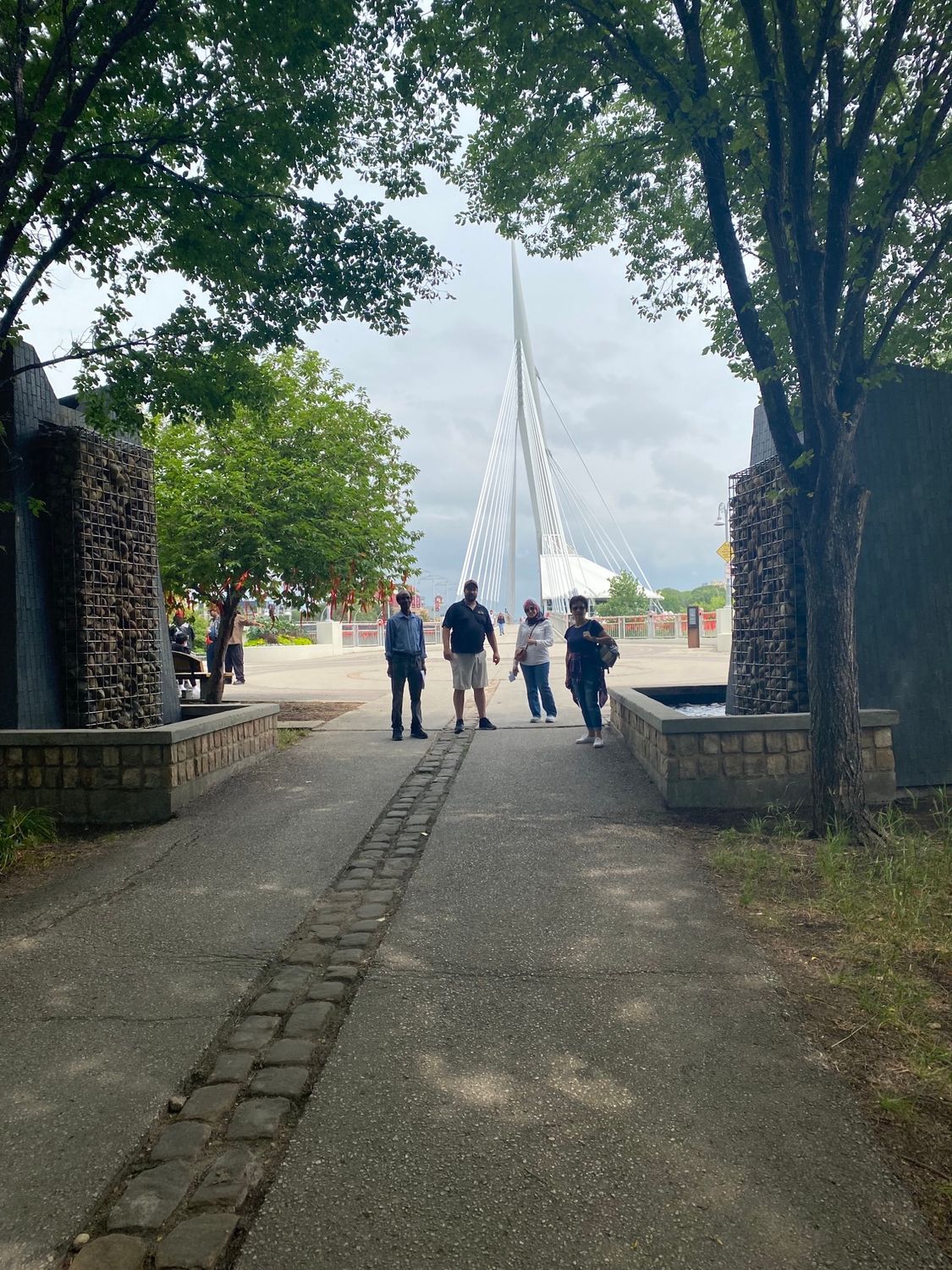 A group of people are walking down a sidewalk in a park.