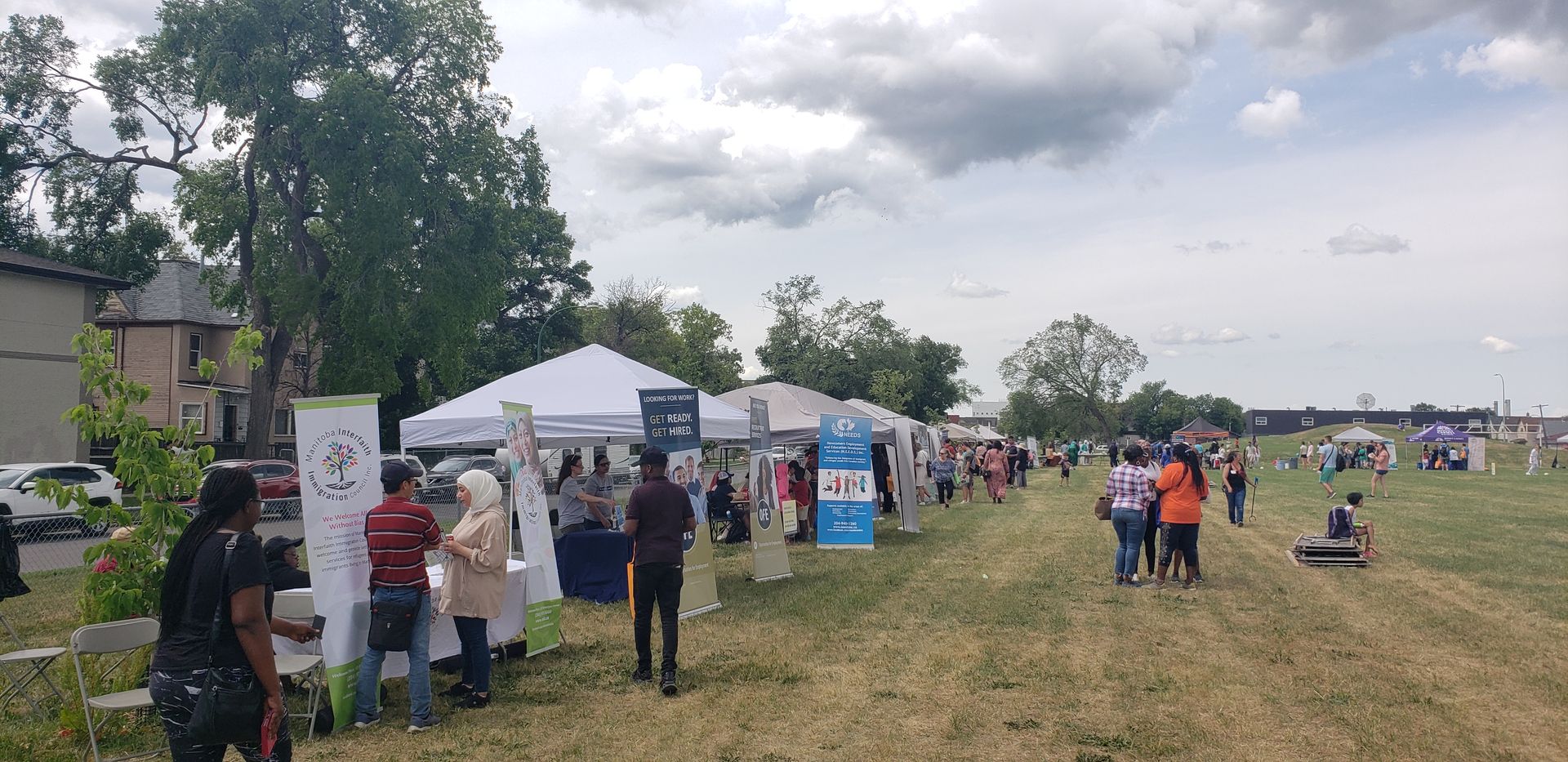 A group of people are standing in a field with tents.