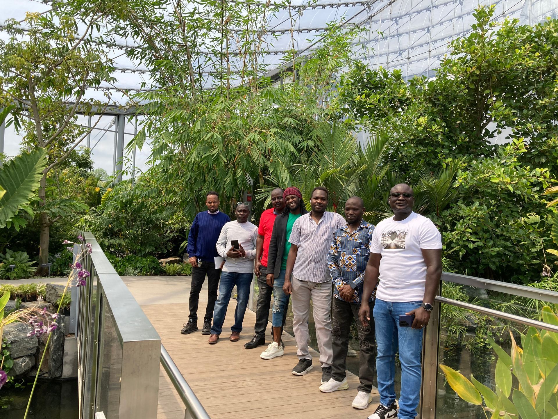 A group of men are standing next to each other on a bridge.