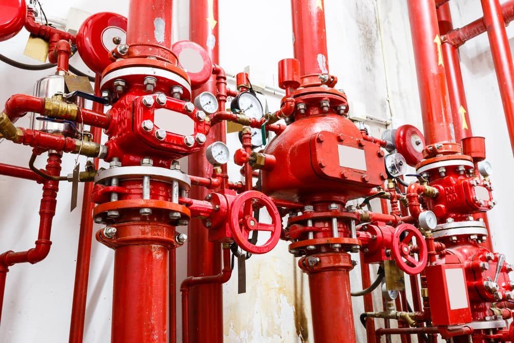 A Bunch of Red Pipes and Valves in a Room — East-West Fire Services In Garbutt, QLD