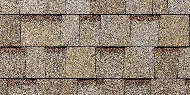 Close-up of tan and brown asphalt roof shingles, slightly weathered.