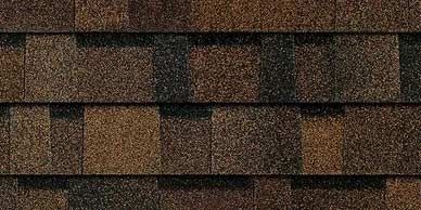 Close-up of brown roof shingles with varying shades and textures.