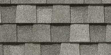 Close-up of gray asphalt roof shingles in an overlapping pattern.
