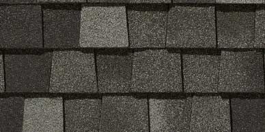 Close-up of asphalt roof shingles in shades of gray and black.