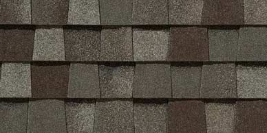 Close-up of overlapping brown and gray roofing shingles.