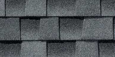 Close-up of dark gray asphalt roof shingles in a repeating pattern.