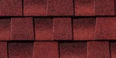 Close-up of red roof shingles in a staggered pattern.