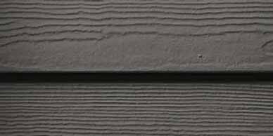 Close-up of dark gray horizontal siding with wood grain texture.