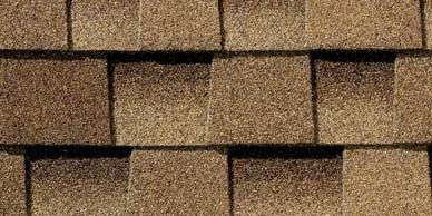 Close-up of brown asphalt roof shingles with a textured, speckled surface.