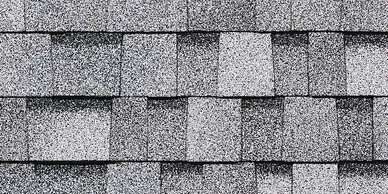 Gray asphalt roof shingles, overlapping in rows.