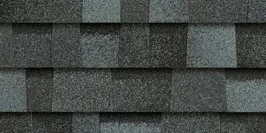 Close-up of gray asphalt roof shingles with varied shades and granular texture.