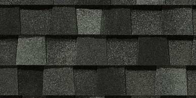 Close-up of asphalt roof shingles in shades of gray and black.