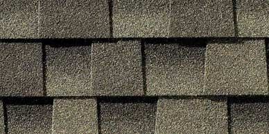 Close-up view of overlapping gray asphalt roof shingles.