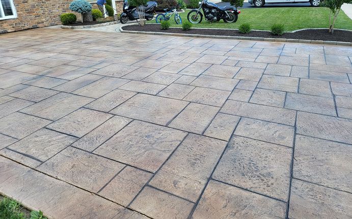 Brown stamped concrete driveway with a rectangular block pattern.