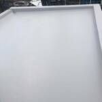 White flat surface with a raised border, possibly a rooftop.