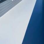 White boat deck and side against blue water.