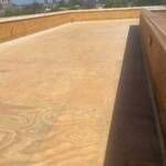 Wooden deck with raised wooden border; sunlight.