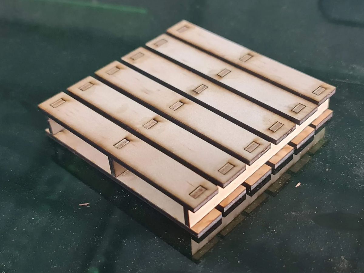 A wooden pallet coaster sitting on a glass table