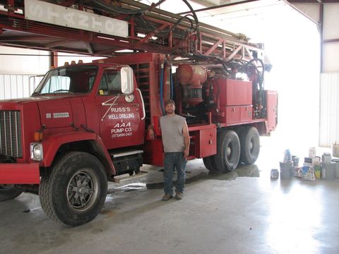 A man standing in front of a red truck