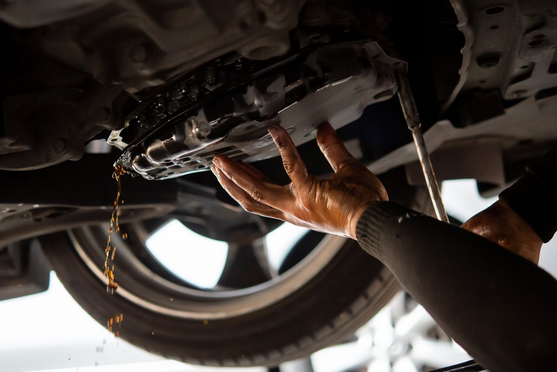 A person is changing the Transmission fluid | C&C Tire Inc.