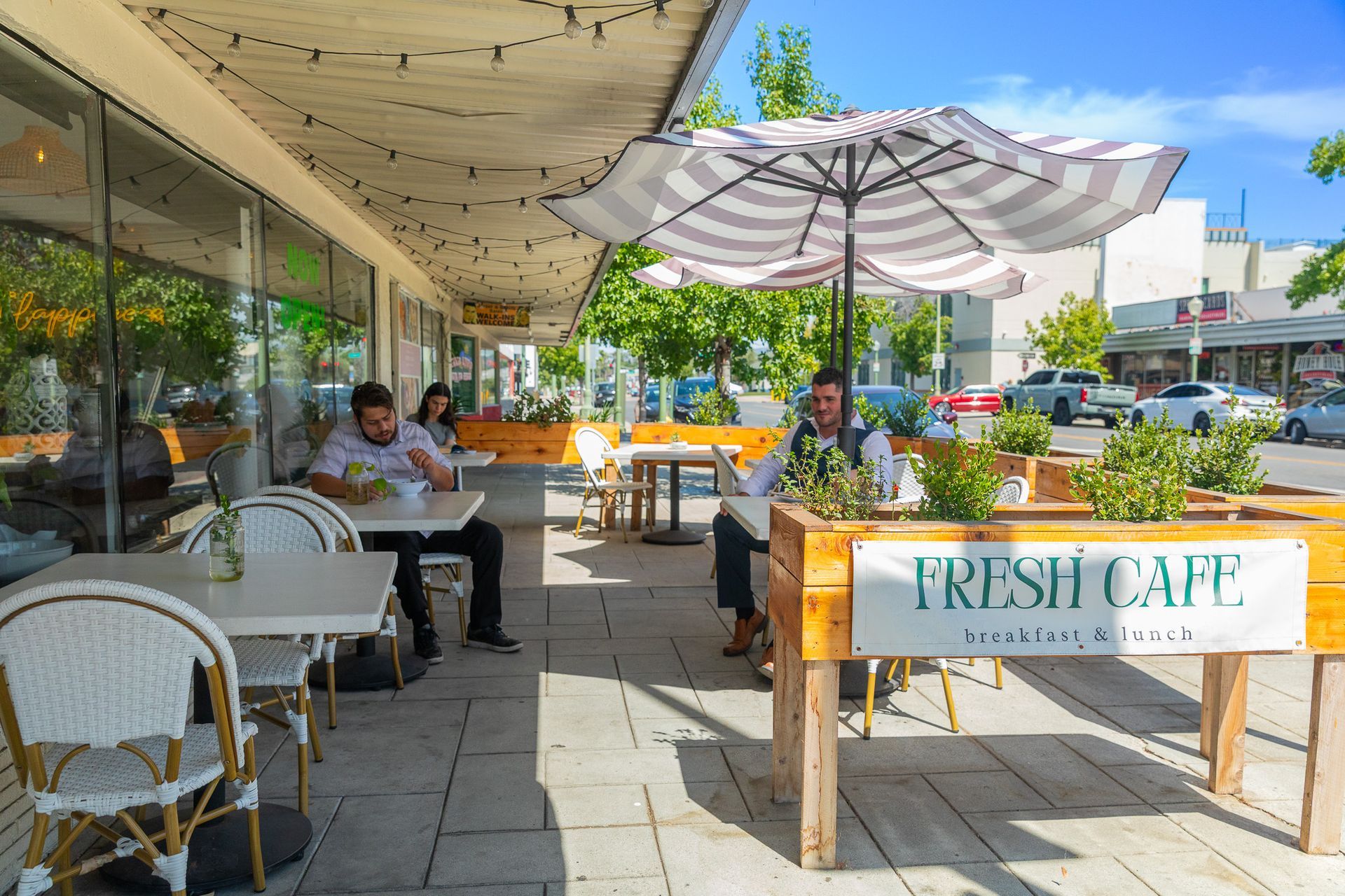 Four women arm-in-arm, smiling, in a light-filled room with neutral tones and decor.
