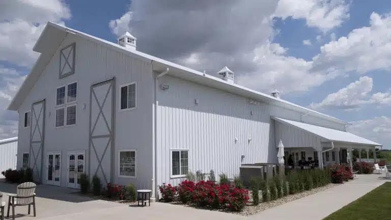 A large white barn with a blue sky in the background.