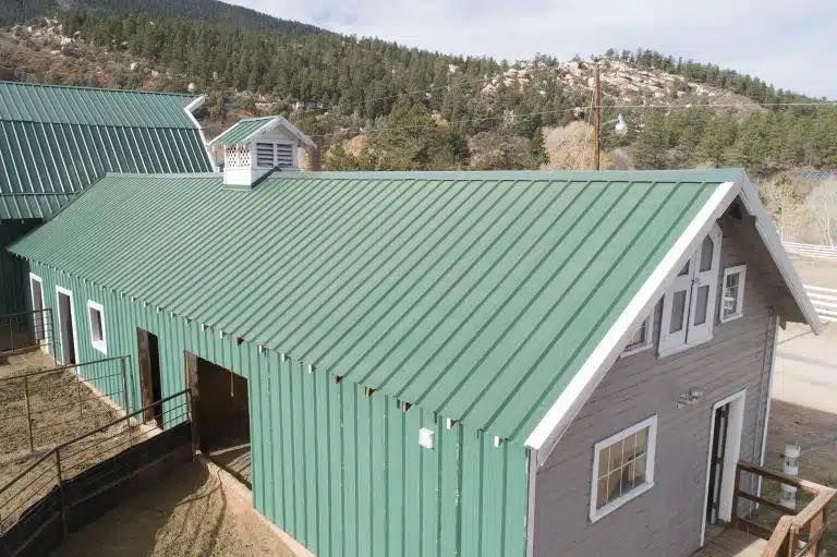 An aerial view of a barn with a green roof.