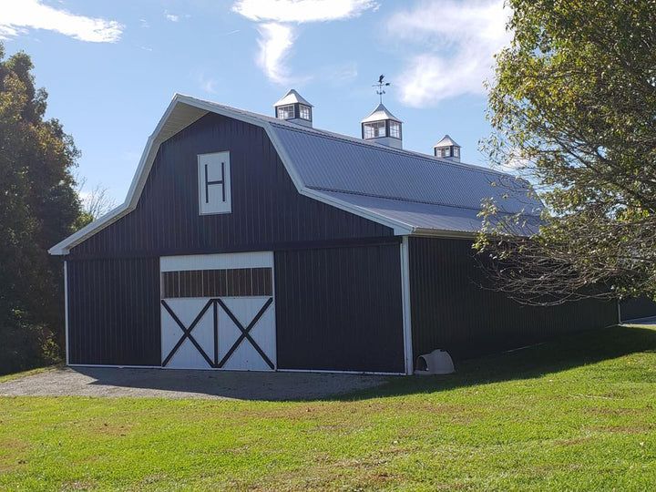 A black barn with a white h on the side