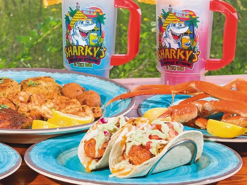 A table topped with plates of food and two mugs with sharks on them