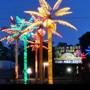 A sign for dove rest rv park is lit up at night