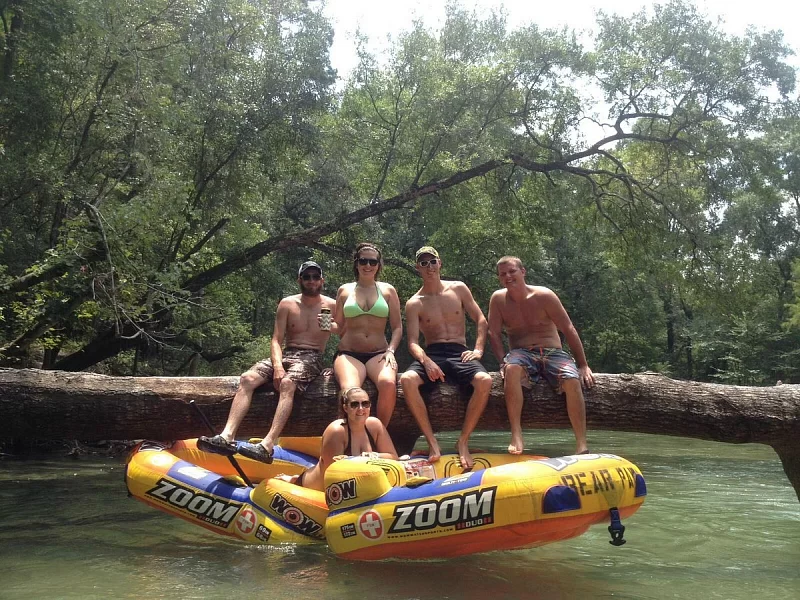 A group of people are sitting on a raft that says zoom