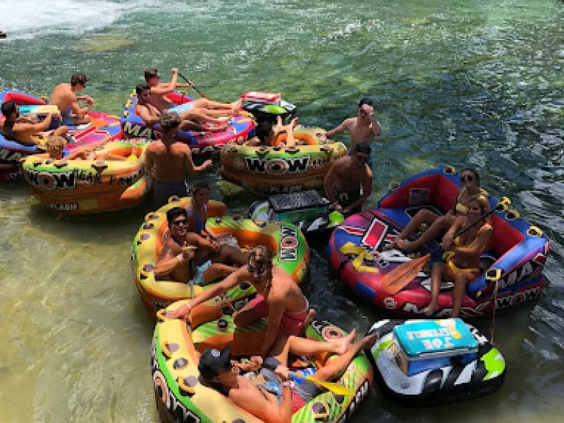 A group of people are floating on rafts in the water.