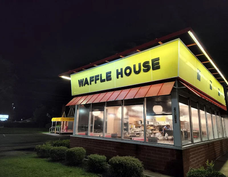 A waffle house restaurant is lit up at night