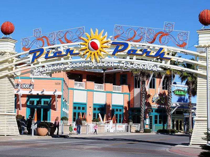 People are walking under a sign that says pier park