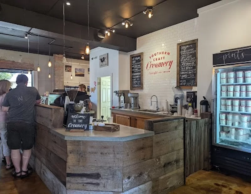 A group of people are standing at a counter in a restaurant.