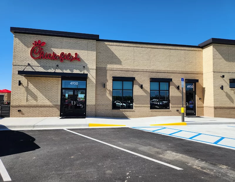 A chick fil a restaurant with a parking lot in front of it