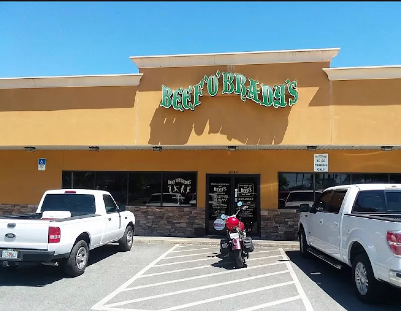A motorcycle is parked in front of a restaurant called bert 's