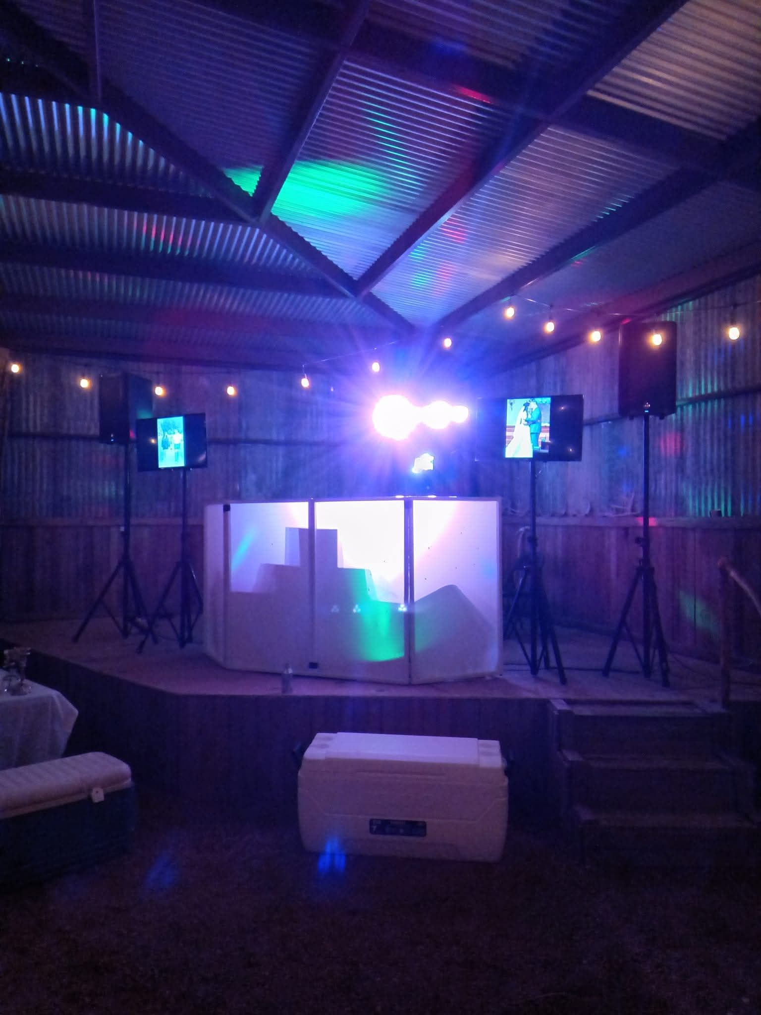A large empty room with a dj booth in the middle of it.